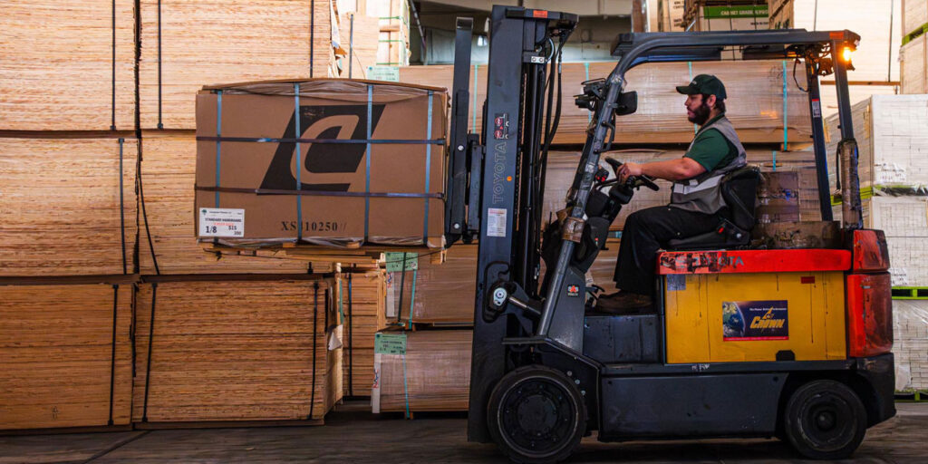 Worker driving forklift