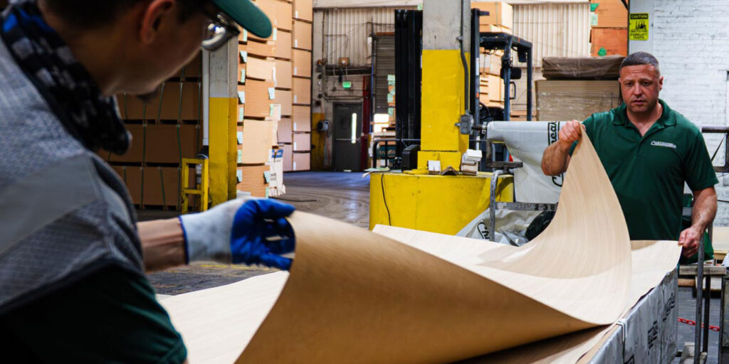 Workers lifting veneer sheets