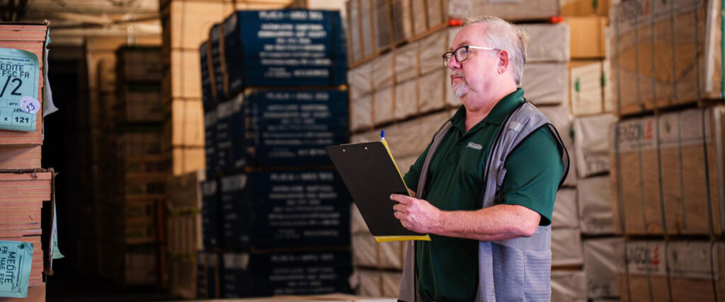 Worker with clipboard in warehouse