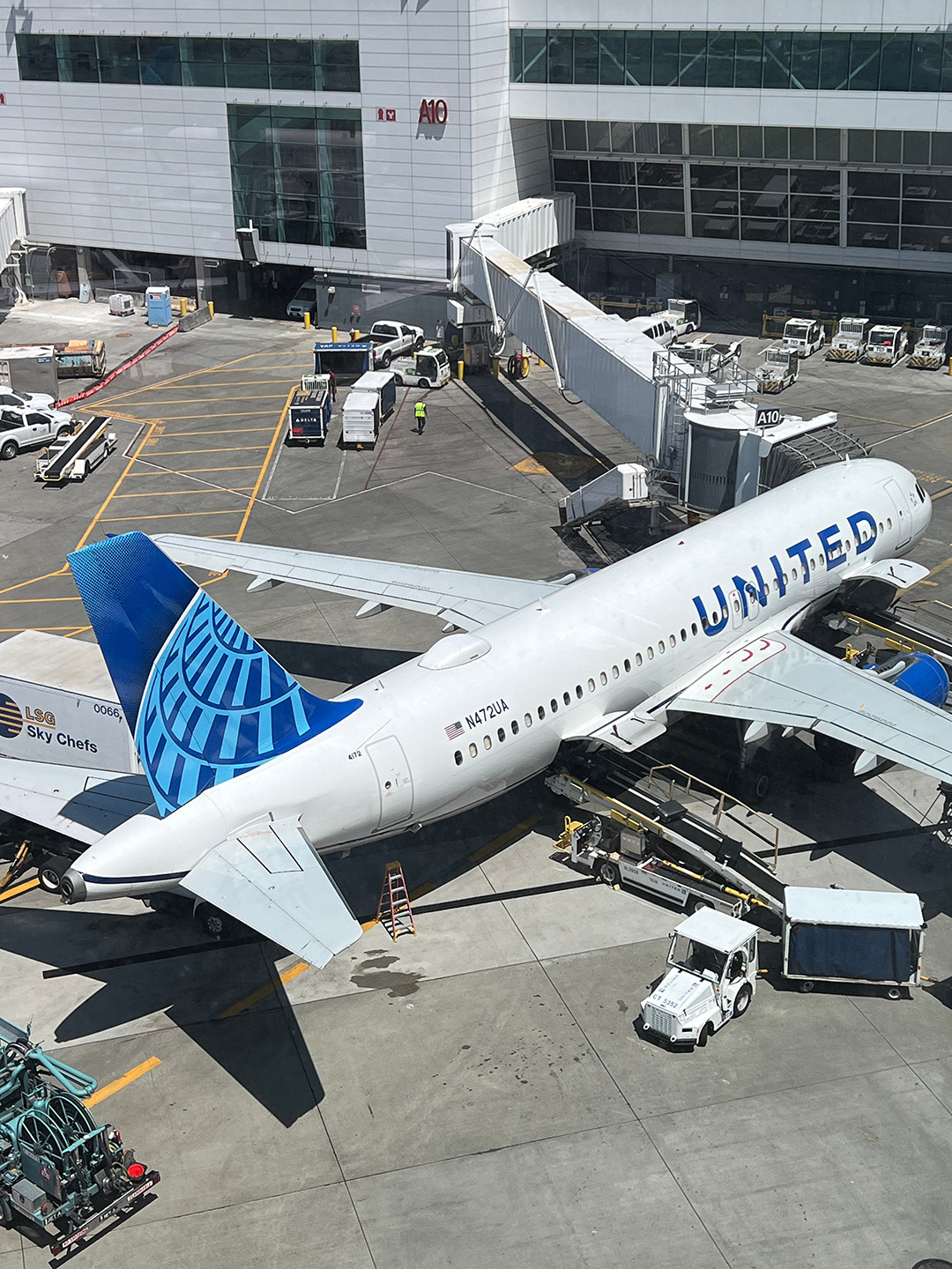 United Airline jet at terminal with gangway extended top view
