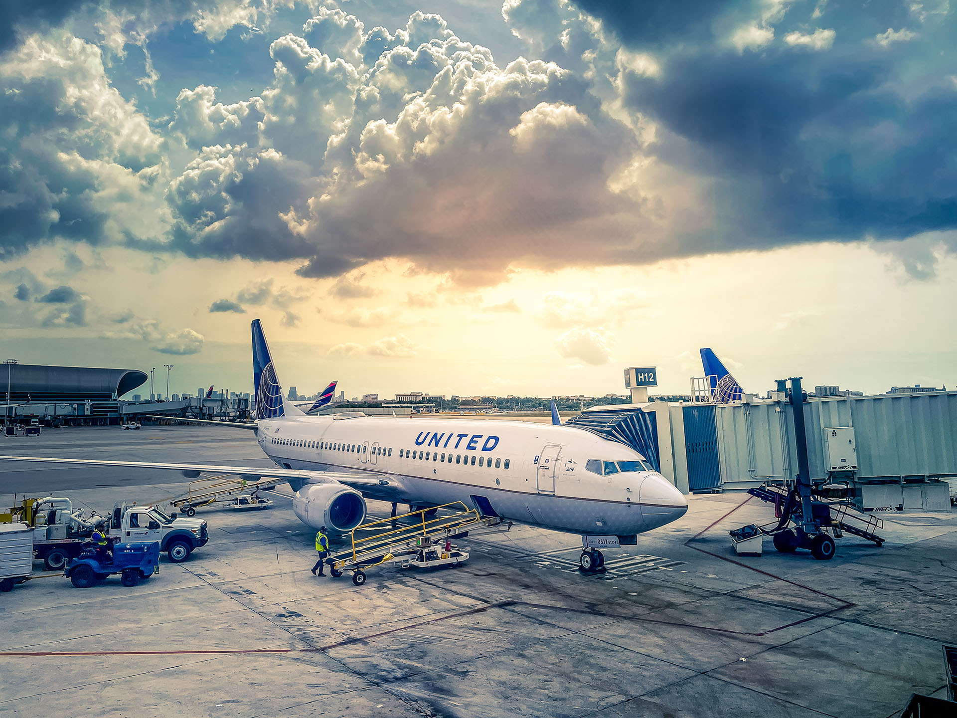 United Airlines jet parked at terminal with jetway extended