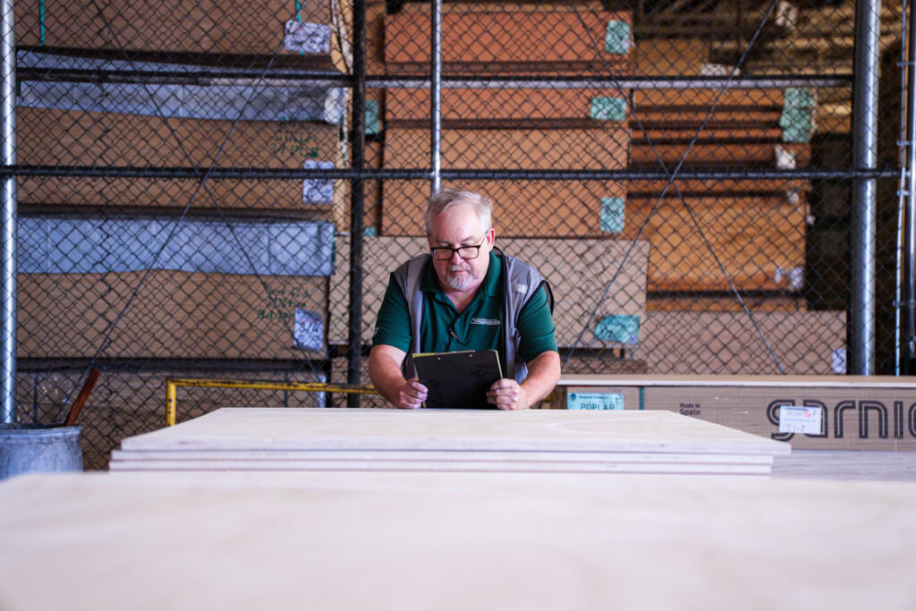 worker checking ipad in wood warehouse closeup 1920 1280