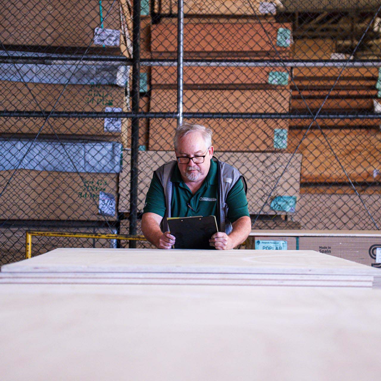 worker checking ipad in wood warehouse Square