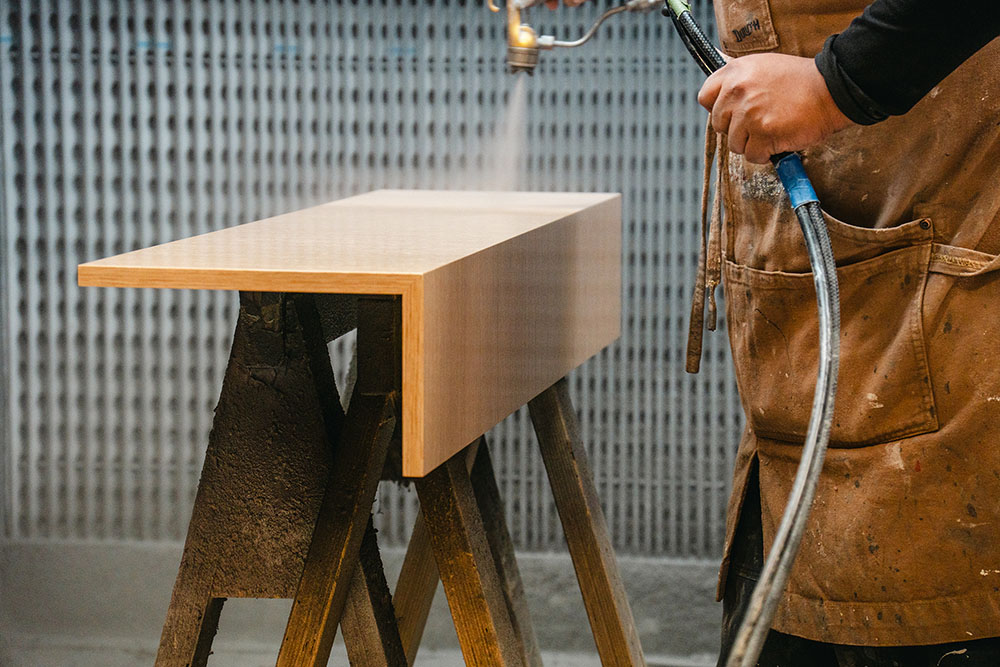 millworker applying wood finish