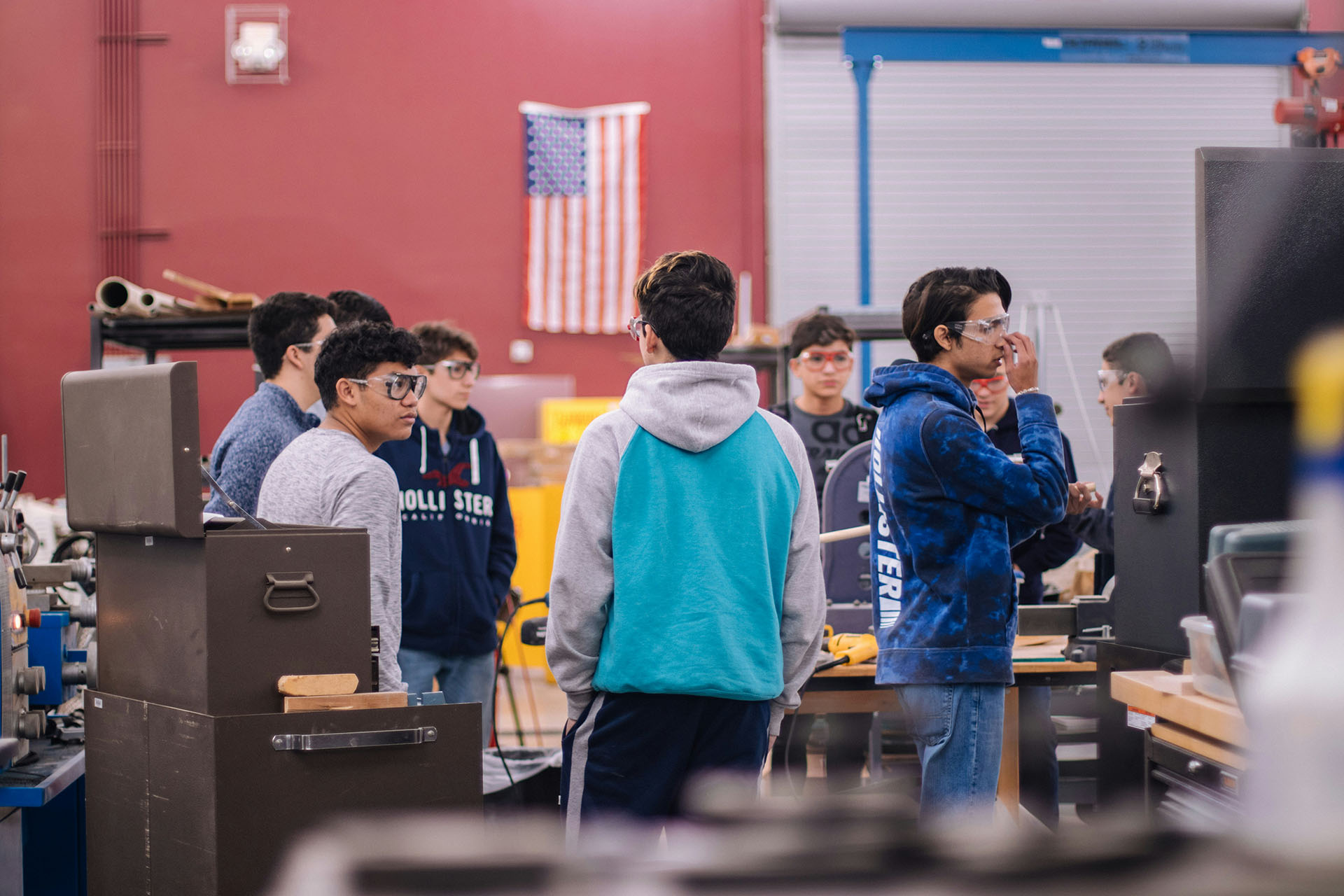 teenagers wearing eye protection during shop class